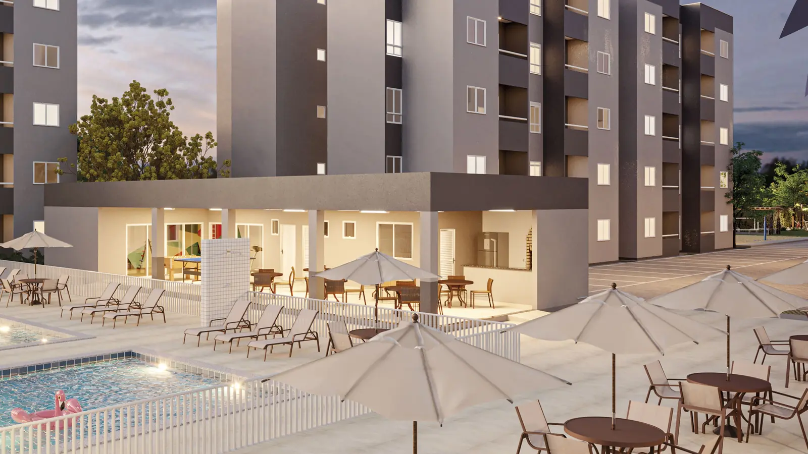 Área de lazer do Gran Village Eusébio III ao entardecer, com a piscina, mesas com guarda-sóis e os blocos de apartamentos ao fundo