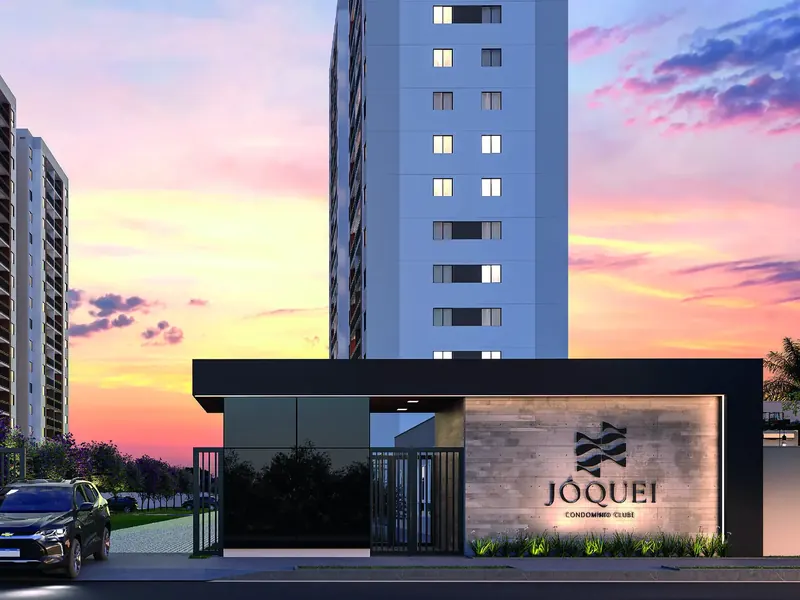 Portaria do Jóquei Condomínio Clube ao entardecer, com o letreiro do empreendimento e a torre ao fundo