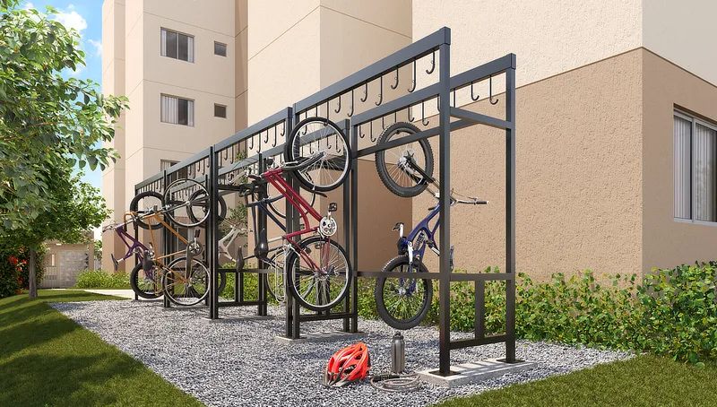 Bicicletário do Laguna Ville, com suportes metálicos e bicicletas, ao lado de um dos blocos