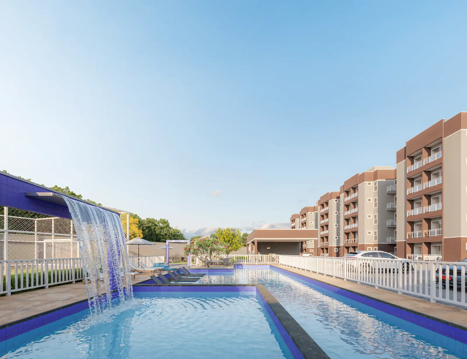 Piscina com cascata do Village Monet, com deck e os blocos ao fundo