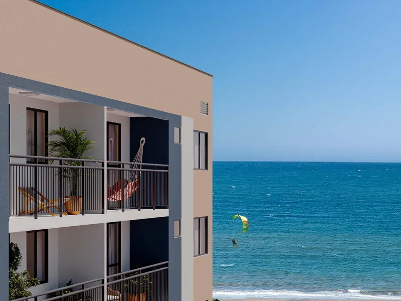 Fachada de uma das torres do Vista Coqueiral, com varandas voltadas para o mar e kitesurfistas ao fundo
