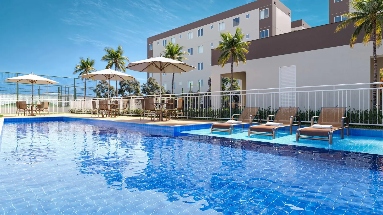 Piscina do Vitória Íris com deck, espreguiçadeiras e coqueiros ao redor